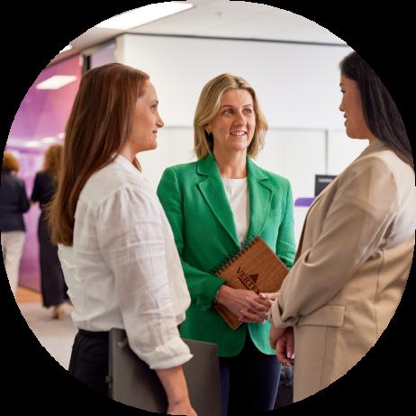 Three employees having a conversation in the Vertex Sydney office