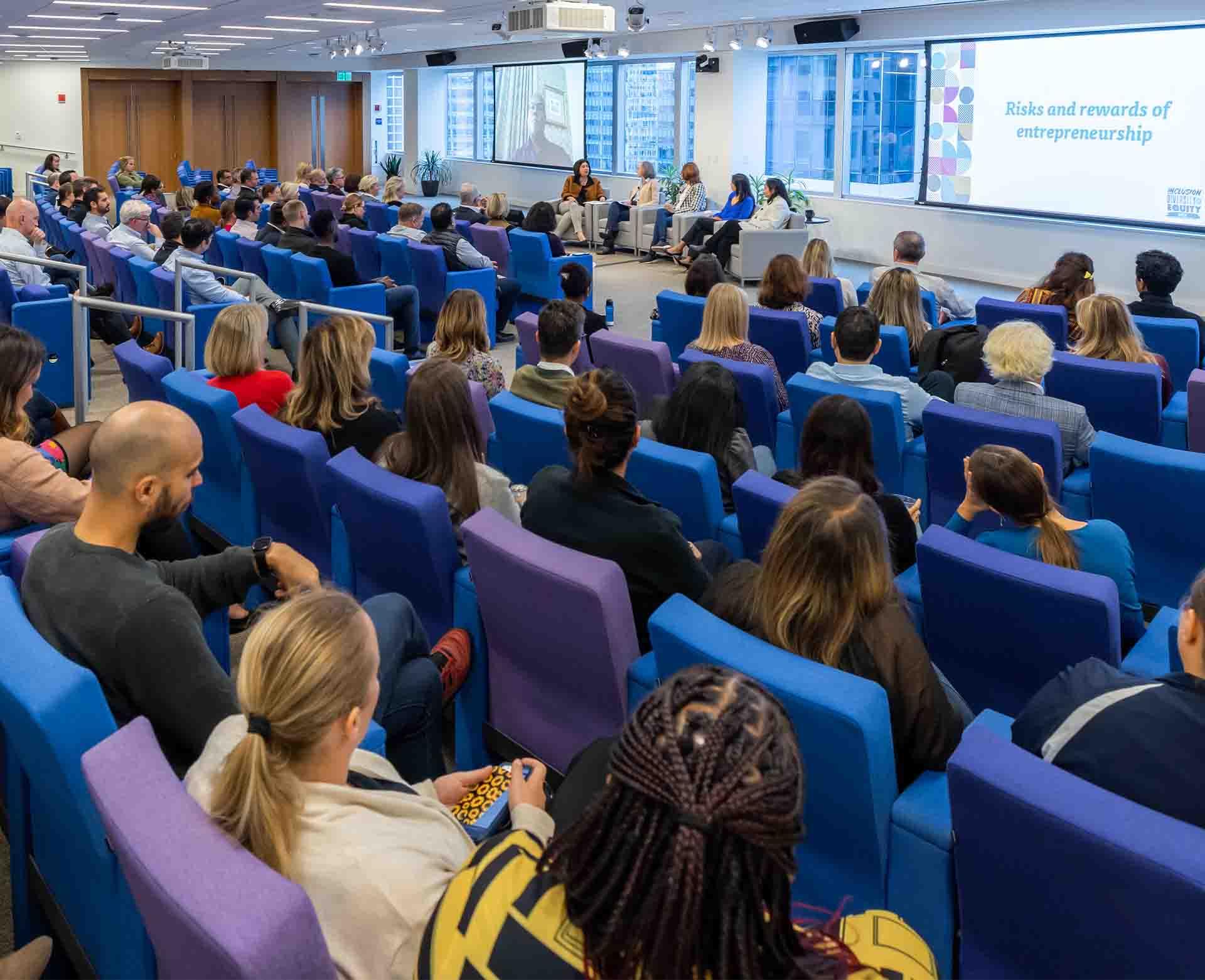 Employees attending an educational presentation in the Vertex auditorium