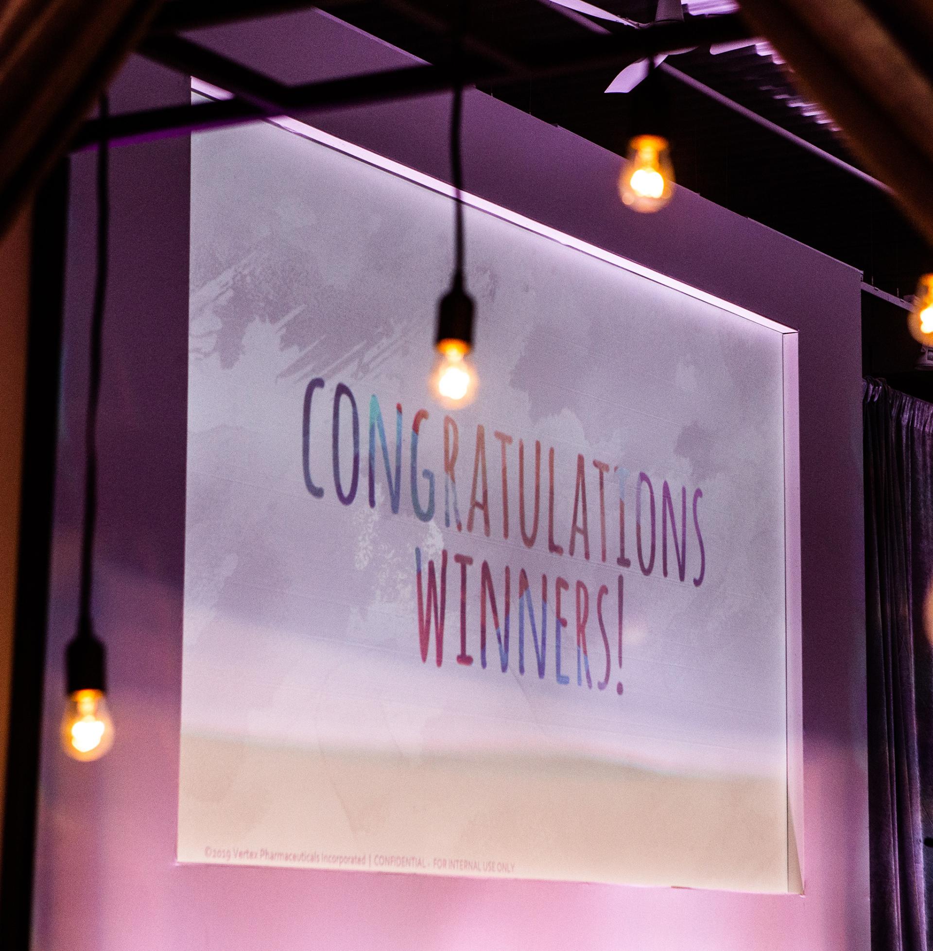 An image on a screen says "Congratulations, winners!"