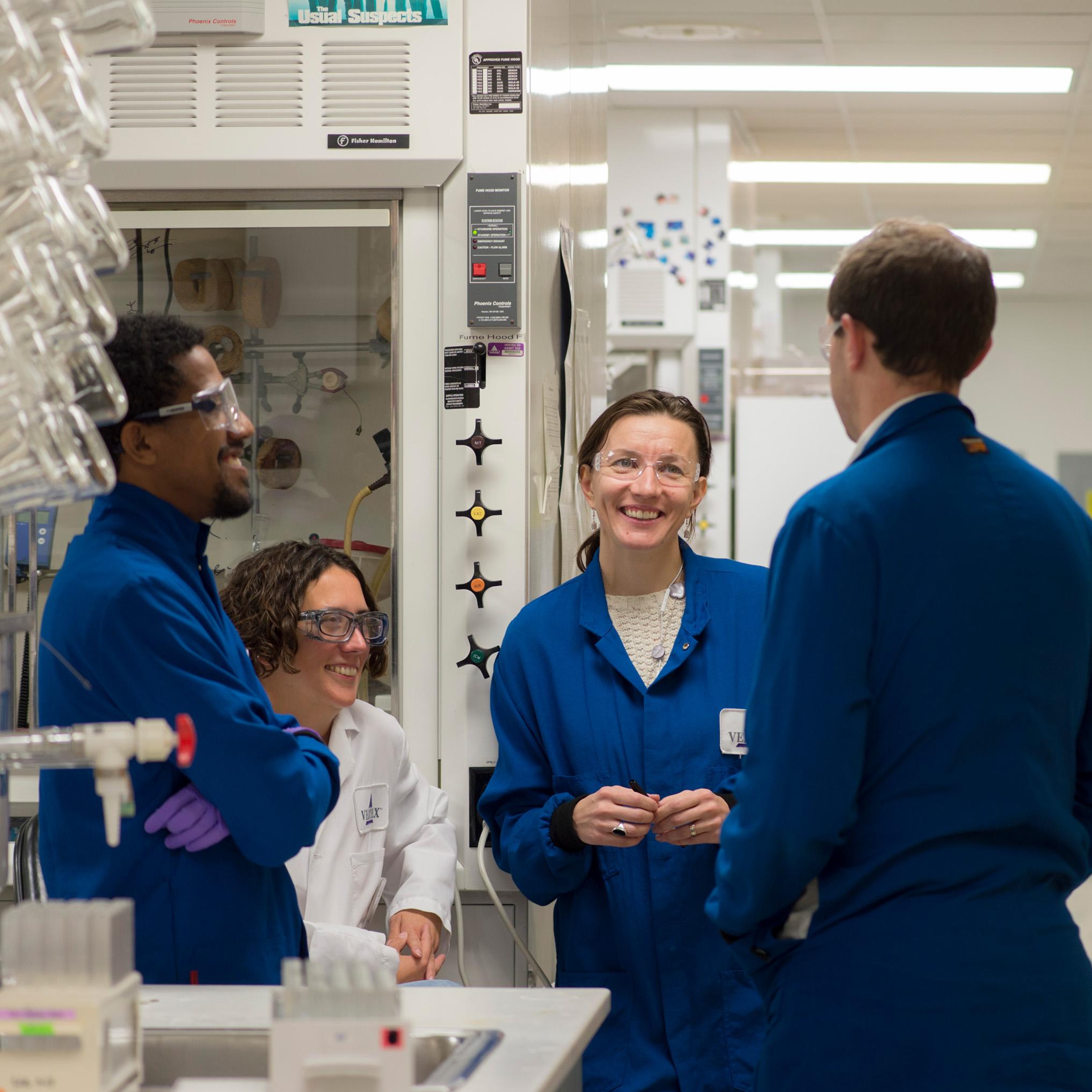 A group of Vertex scientists having a friendly conversation in a lab