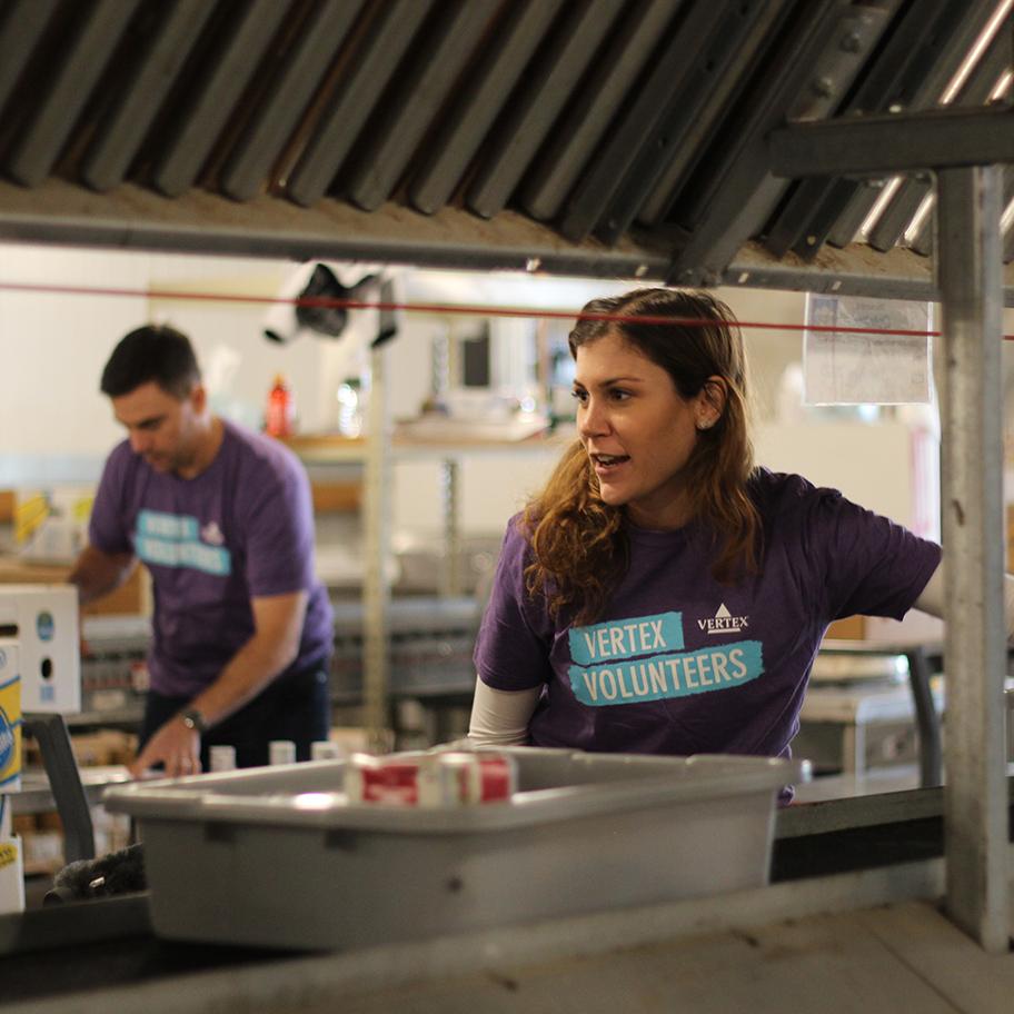 Two Vertex volunteers helping out in a kitchen