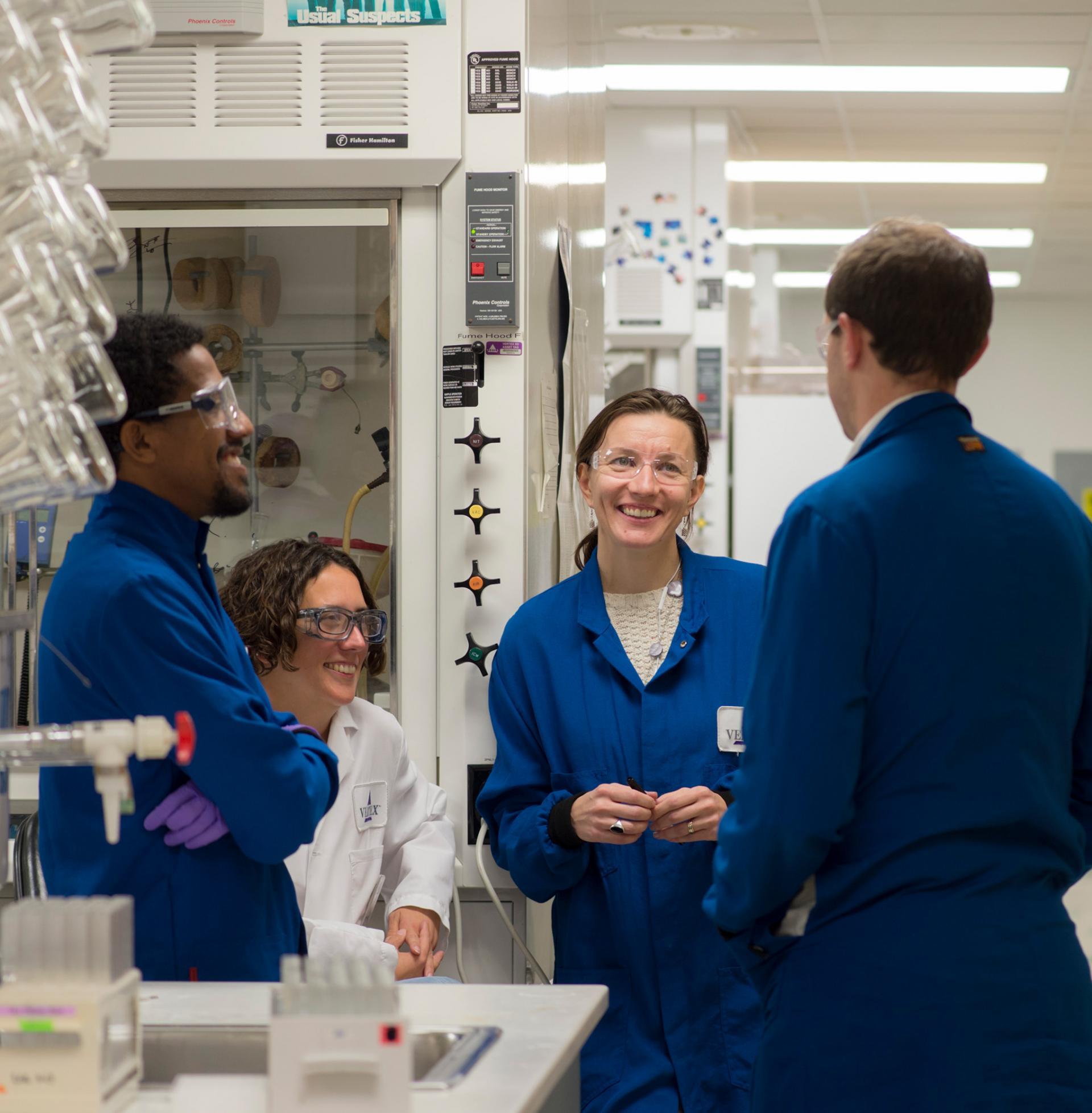 A group of Vertex scientists having a friendly conversation in a lab