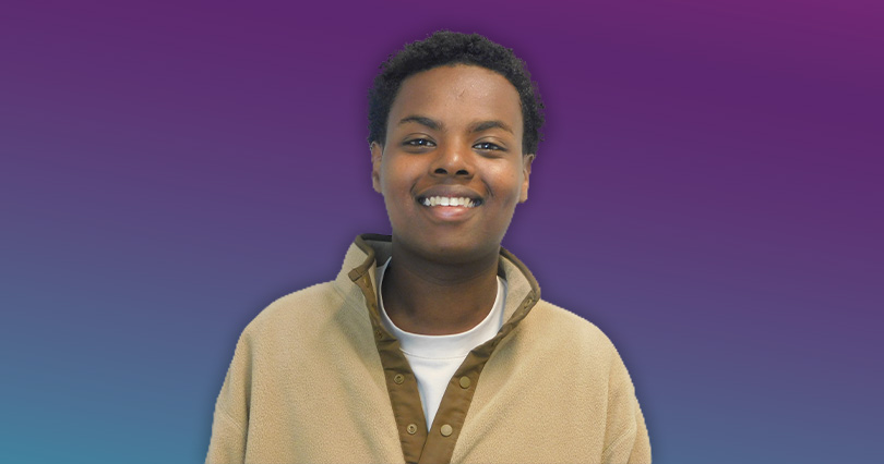 An image with a purple background of Sharmarke Mohamed smiling.