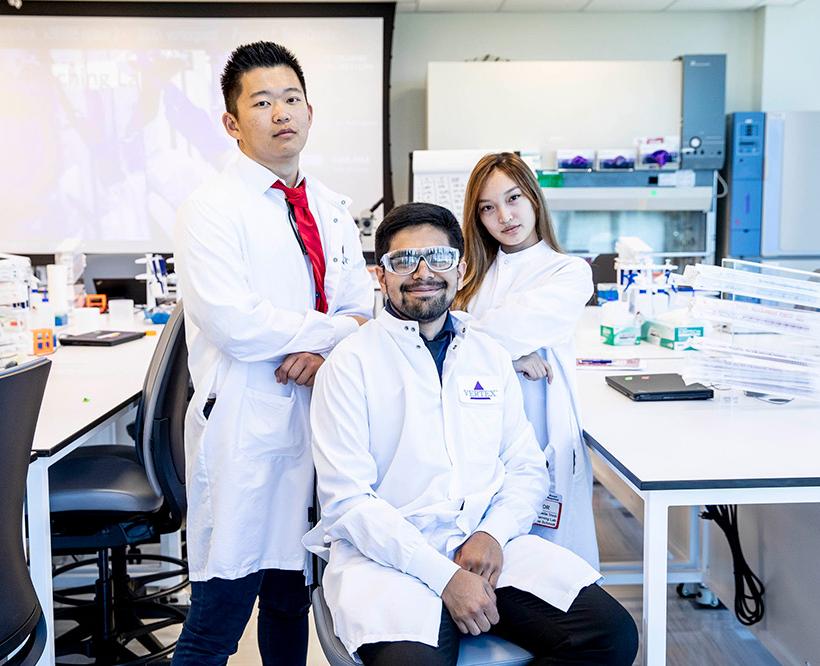 3 STEAM Students posing in Vertex lab coats in the Learning Labs