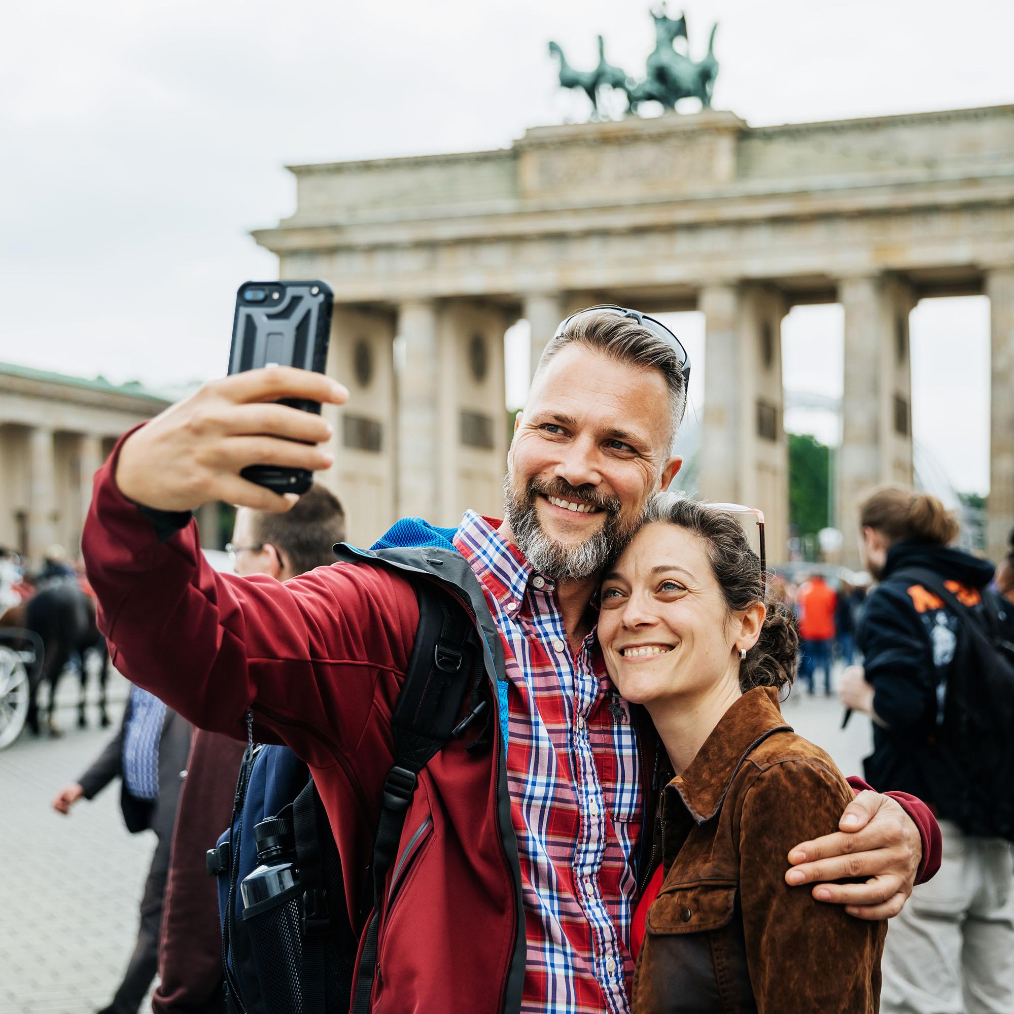 A couple poses together for a selfie while on a vacation